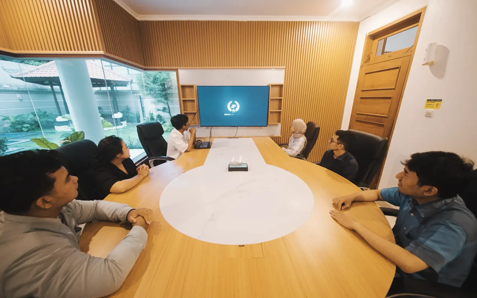 A board meeting under way in a private Bali meeting room with a presentation screen