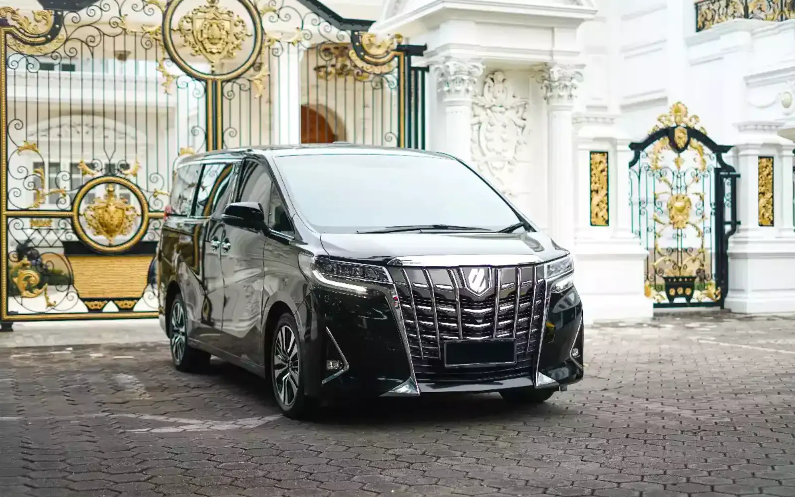 An executive Toyota Alphard waiting at a villa gate for a scheduled investor transfer