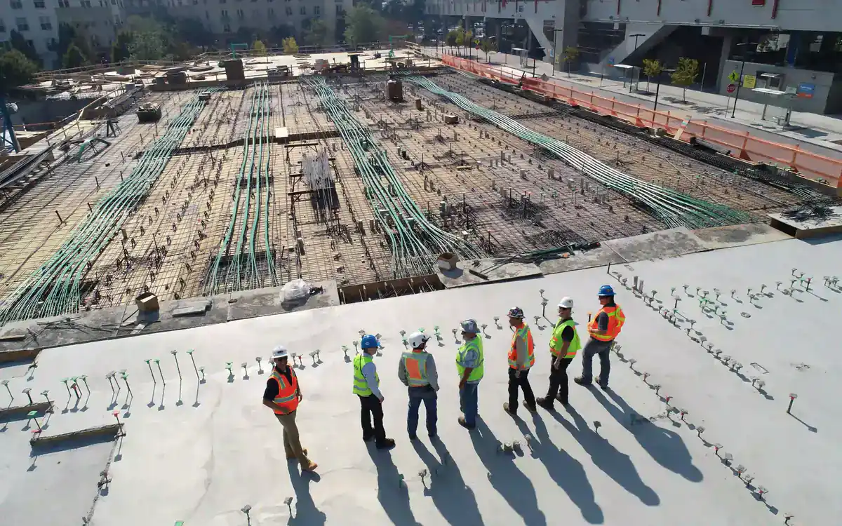 Construction crews on a large reinforced foundation slab at an early-stage development site